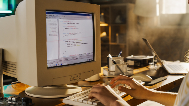 a person typing on an old computer