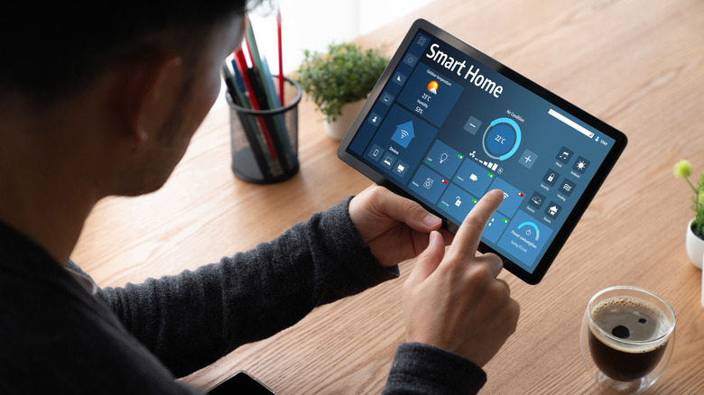 A person setting up a smart home system on a tablet.