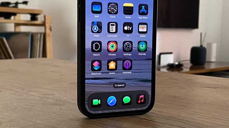 An iPhone standing on a table with its Home Screen on