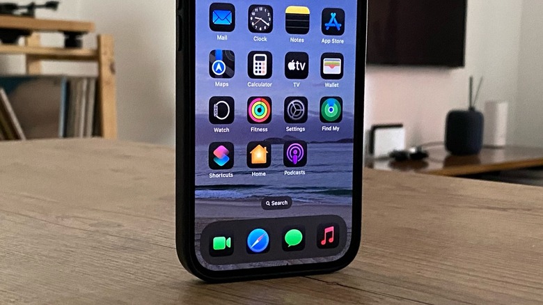 An iPhone standing up on a wooden table