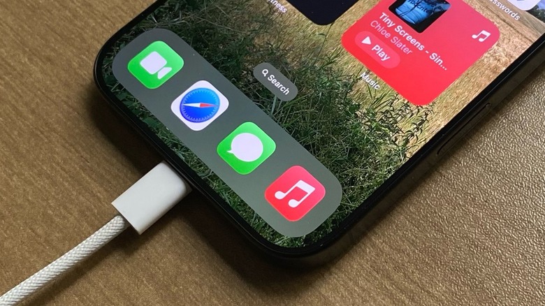 An iPhone charging on a desk with a USB-C braided cable