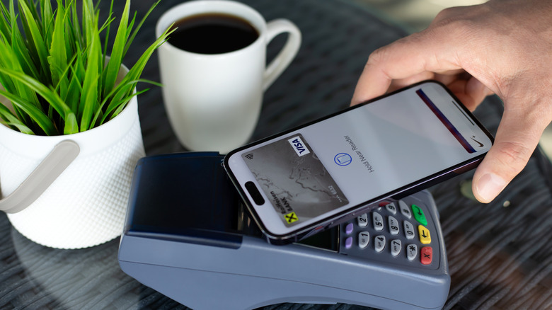 A person using Apple Pay in a coffee shop.