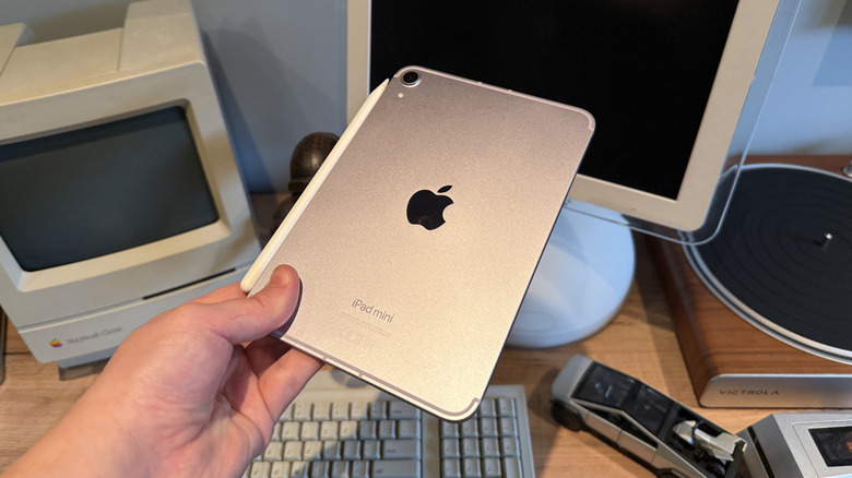 Rear of 2024 iPad mini being held by one hand with Apple Pencil Pro