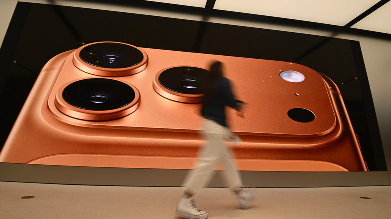 A consumer passing by an iPhone 17 Pro billboard.