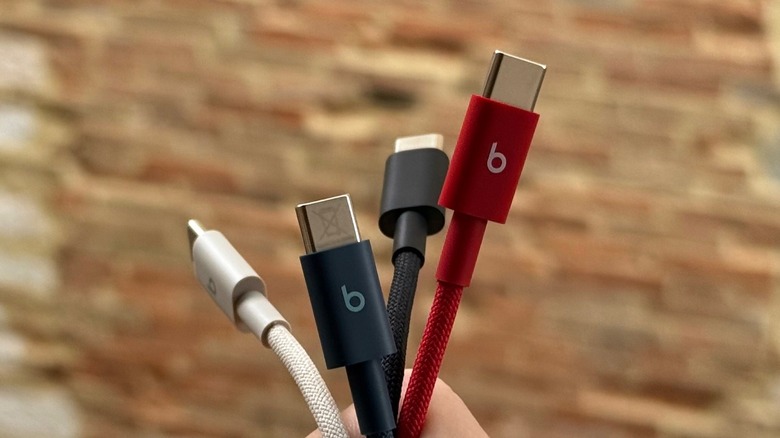 Hand holding several Beats cables