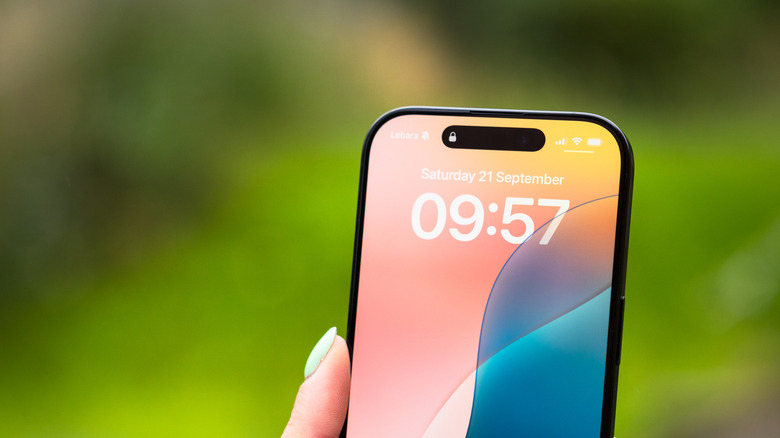 The Face ID unlock Live Activity (the lock icon) appears in the iPhone 16 Pro's Dynamic Island.