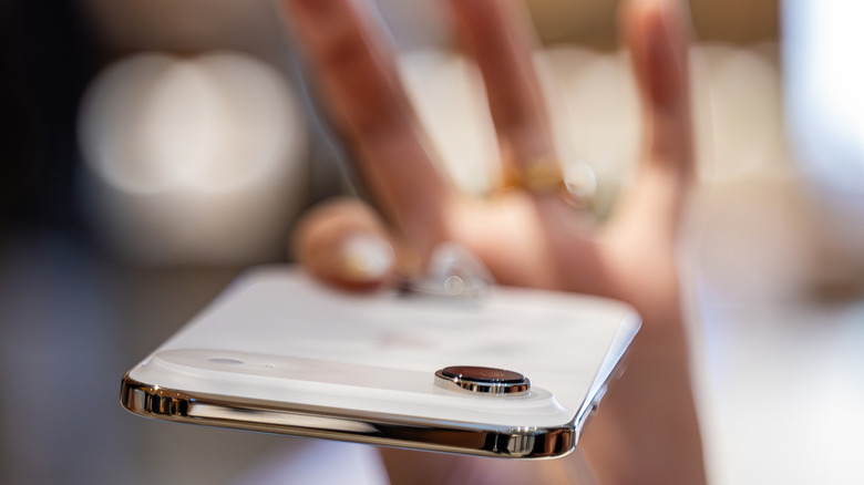 A customer holding the ultra-thin iPhone Air in hand, showing its profile.
