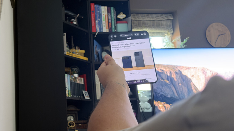 Reading an article on the iPhone Duo, photographed over the shoulder