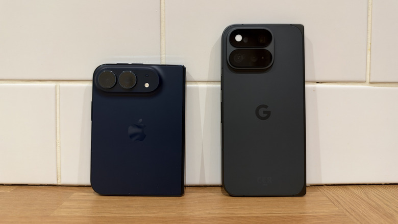 iPhone Duo stood next to Pixel 11 Pro Fold in front of white tiles