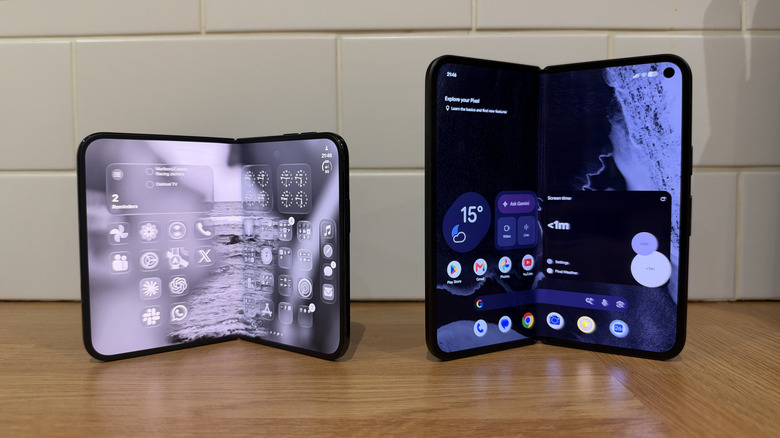 iPhone Duo and Pixel 11 Pro Fold semi-folded standing next to one another in front of white tiles