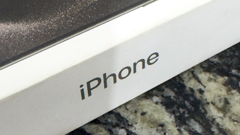 A close-up shot of an iPhone box resting on a patterned granite surface