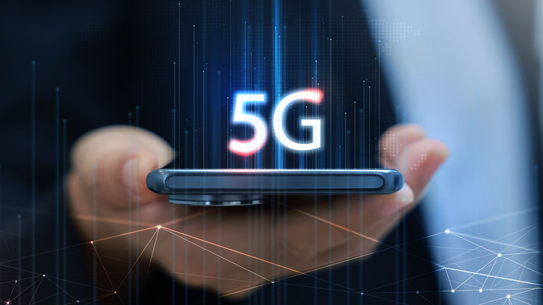 Hand holding smartphone with 5G icon and network interface