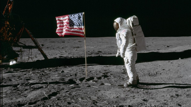 Buzz Aldrin on the moon next to the US Flag