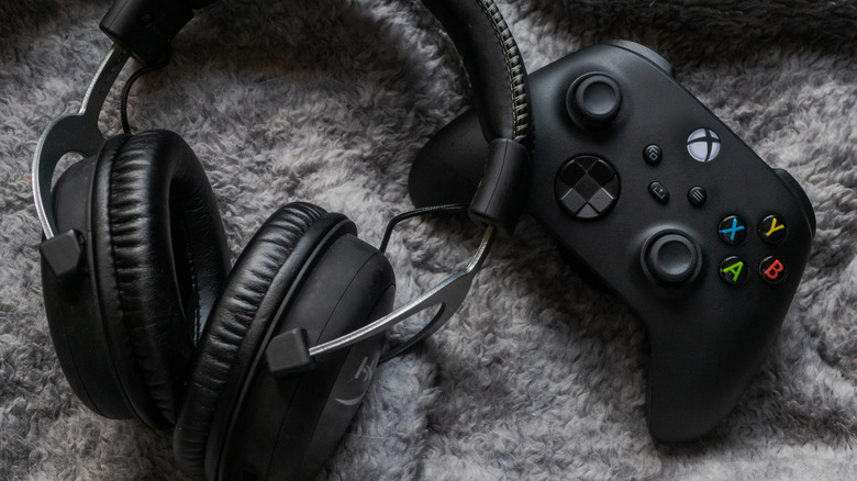 An Xbox controller with a pair of headphones.