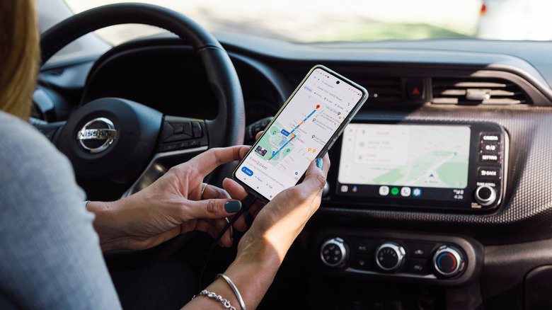 Woman using Android phone connected to Android Auto in her car
