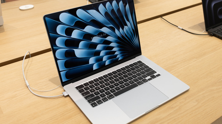 An Apple MacBook Air Laptop computer at an Apple Store connected to a charger
