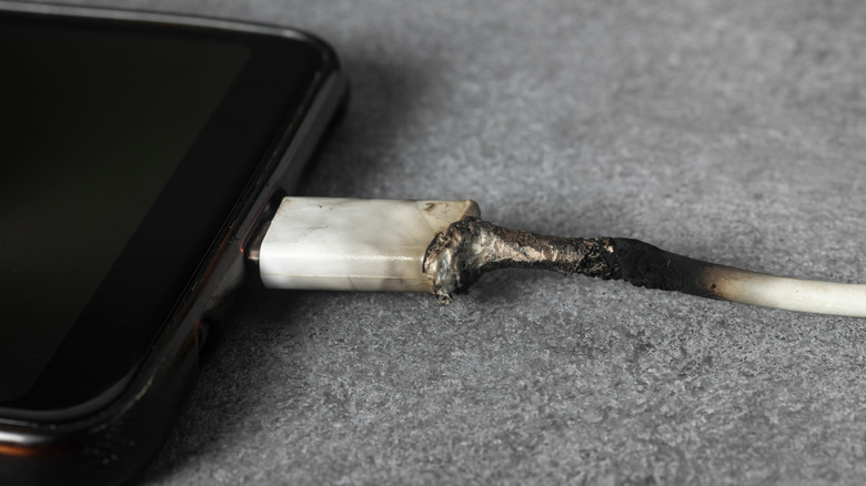 A melted phone charging cable plugged into a phone