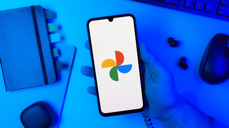 Phone in hand with Google Photos icon on screen