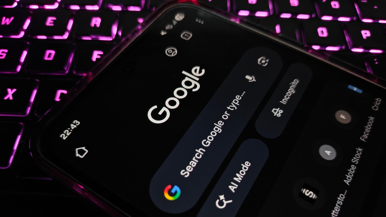 Google opened on a close-up of a smartphone on top of pink-lit keyboard