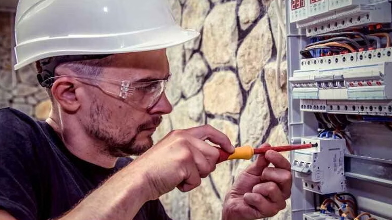 An electrician working on an electrical panel.