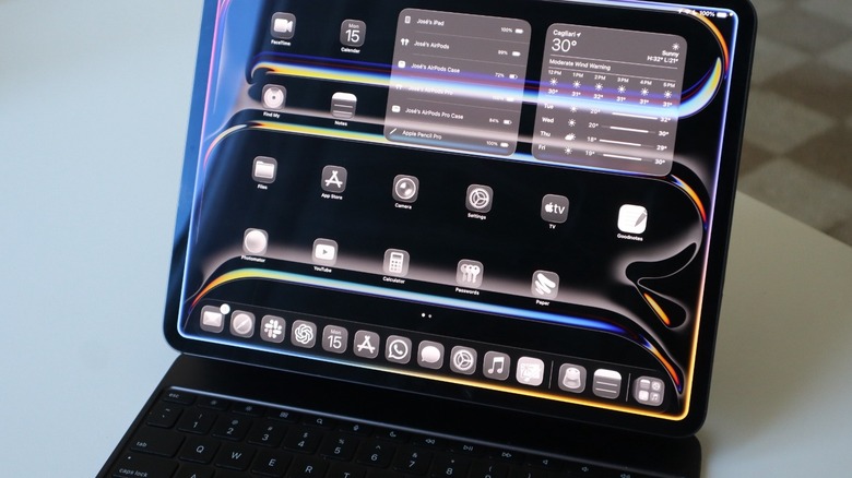An iPad Pro attached to a Magic Keyboard on a white table