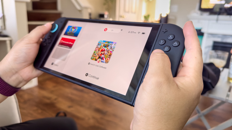 Hands grip a Nintendo Switch 2, displaying Mario Kart World on its screen