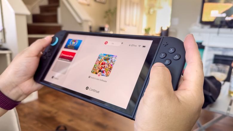 person playing switch 2, waking it up from sleep to continue a game