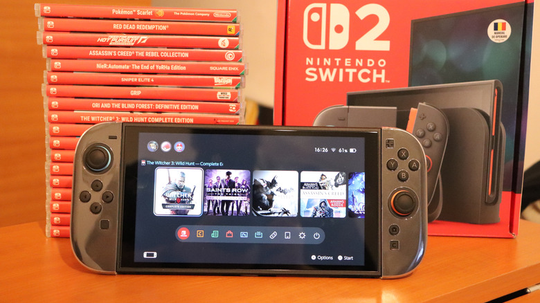 switch 2 sitting in front of switch 2 box and stack of game boxes