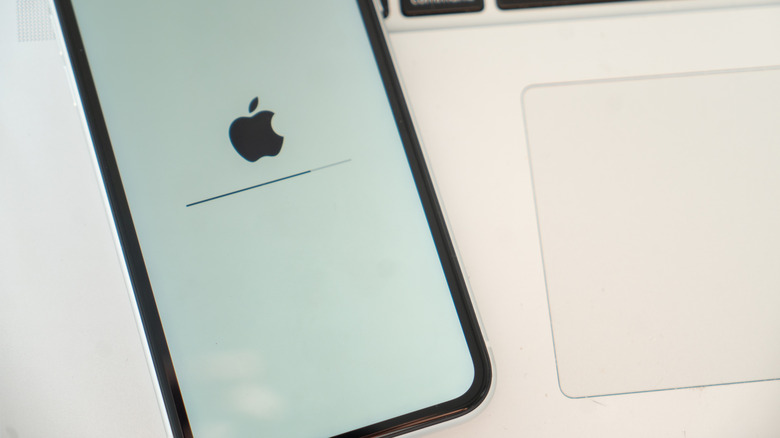 An iPhone loading next to a MacBook