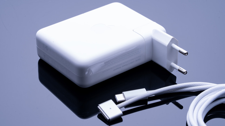 An Apple 140W power adapter next to the MagSafe 3 cable.