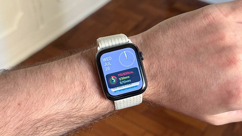 An Apple Watch with a white band on a man's wrist