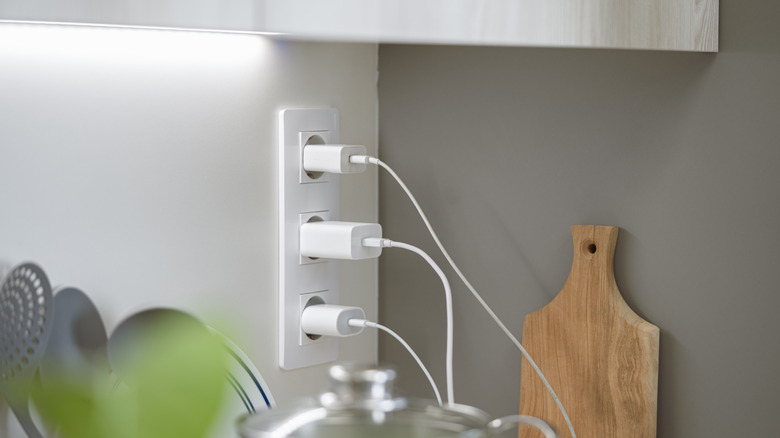 Multiple USB phone chargers plugged into an outlet.