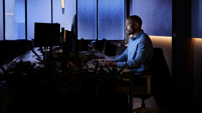 A person working at a PC in the dark
