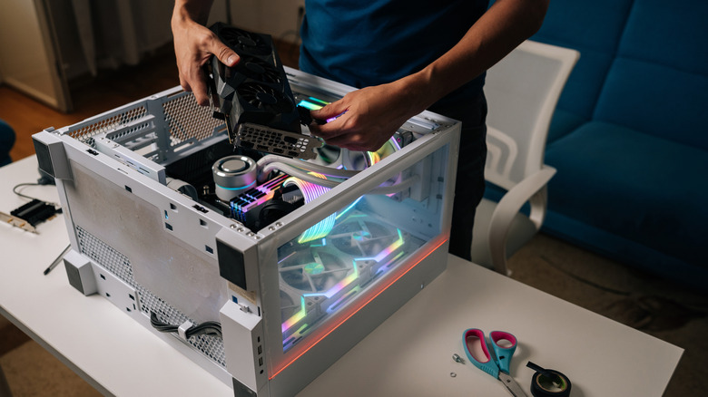 Person installing a graphics card inside a desktop PC case