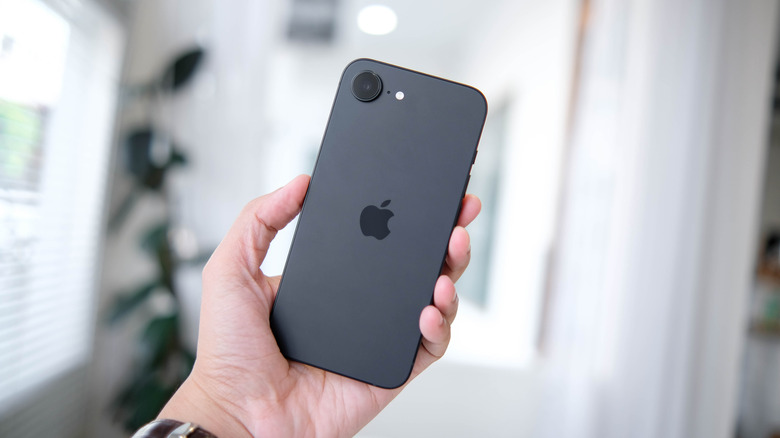 The iPhone 16e in hand: Rear panel and camera view.