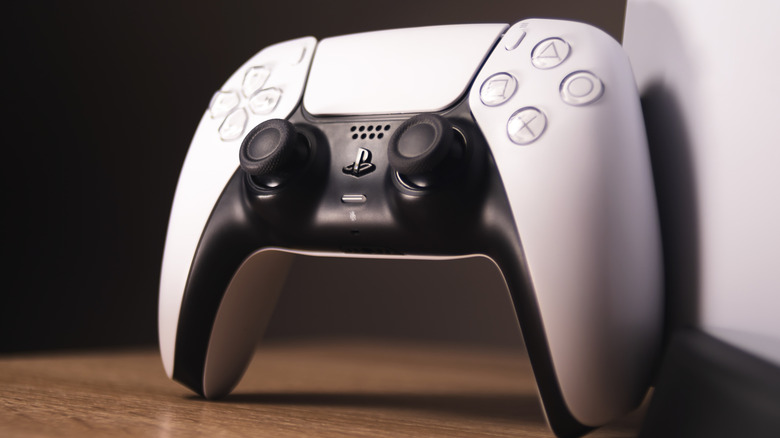 A PlayStation 5 DualSense controller standing on a table.