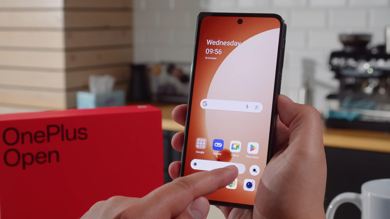 a person touching a OnePlus Open with their finger