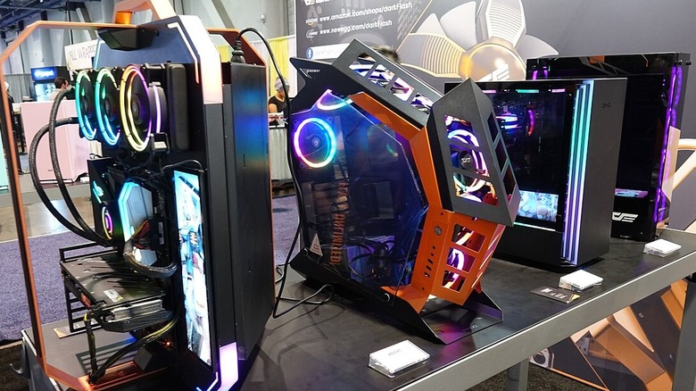 A series of gaming PCs on display featuring LED-lit components and irregularly shaped, angular cases.