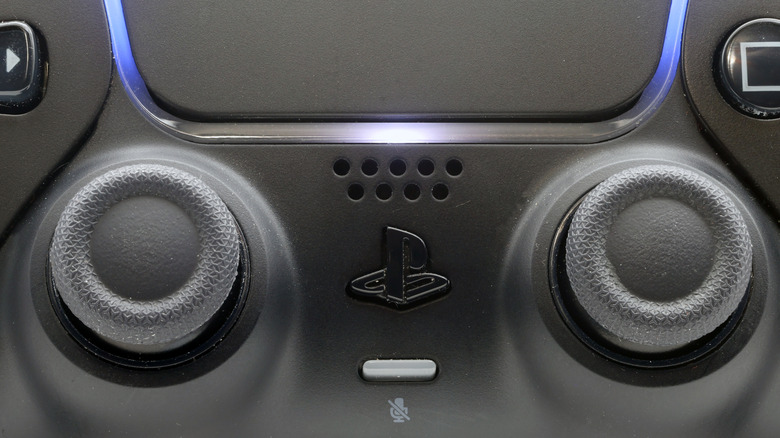 Extreme close-up of a powered-on Midnight Black DualSense controller.