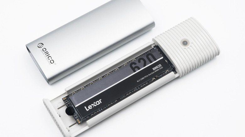 A silver M.2 SSD drive set against a plain white background.