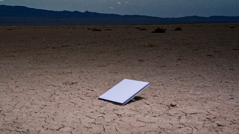Starlink satellite internet dish placed on desert ground under a starry night sky