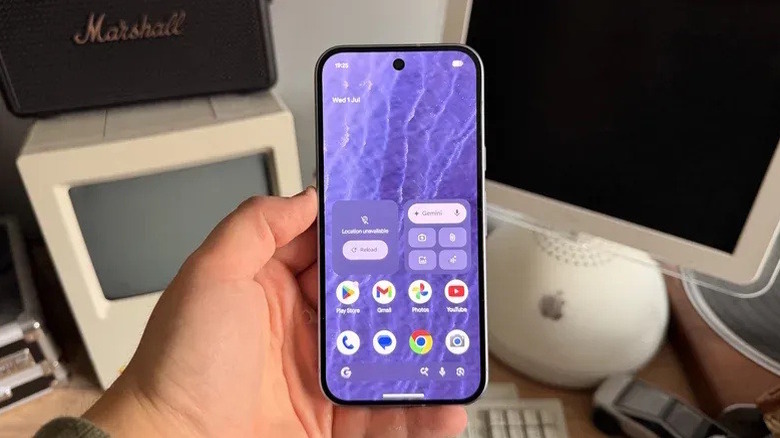 A person holding a Pixel 11 showing the Pixel UI home screen