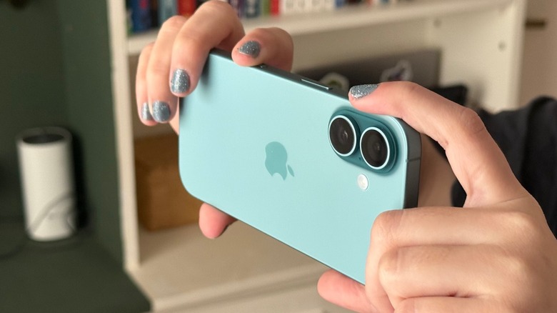 A woman taking a picture with the iPhone 16 using the Camera Control functionality