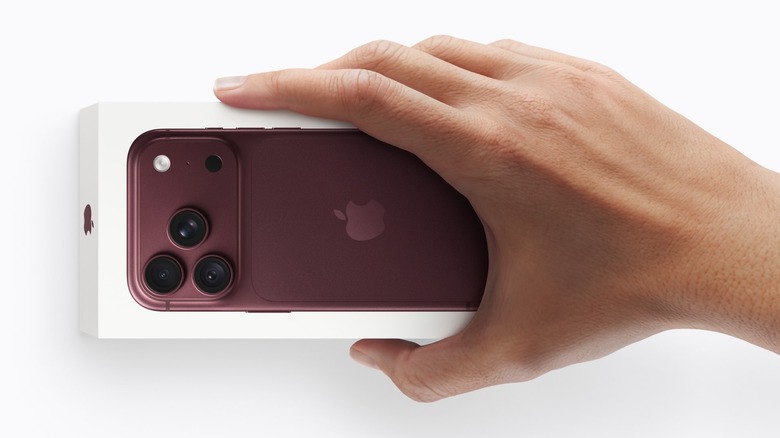 Close-up of a person holding an iPhone 18 Pro box on a white background