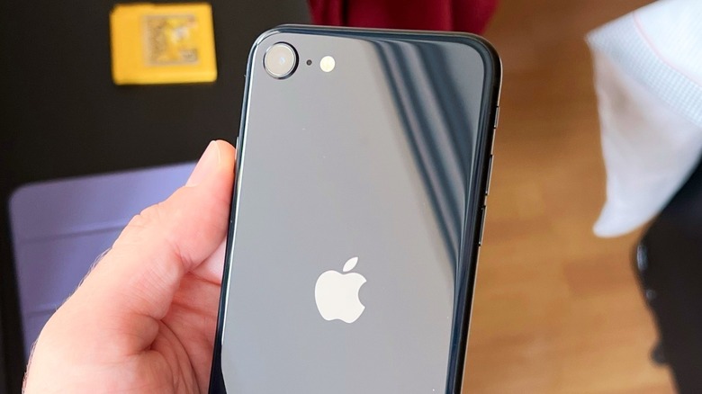 A hand showing the back of the iPhone SE 3