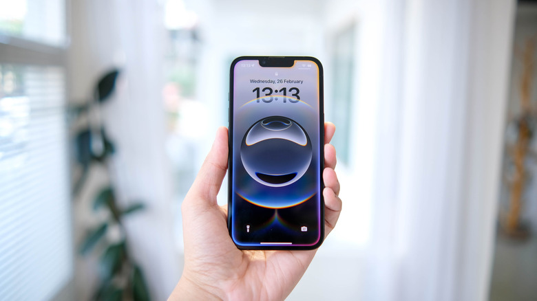 A hand holding the iPhone 16e