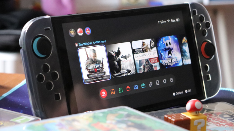 A Nintendo Switch 2 in a clear case with game cases and Mario-themed figures in front of it