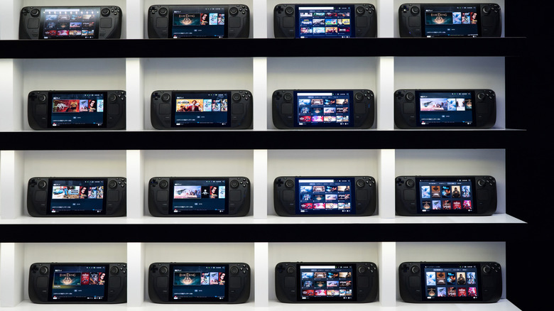 Several Steam Deck consoles arranged on shelves