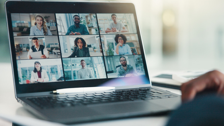 Person watching a laptop screen of a live video feed.
