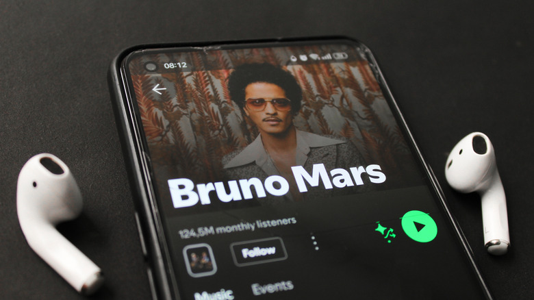close-up of smartphone with pair of airpods next to it